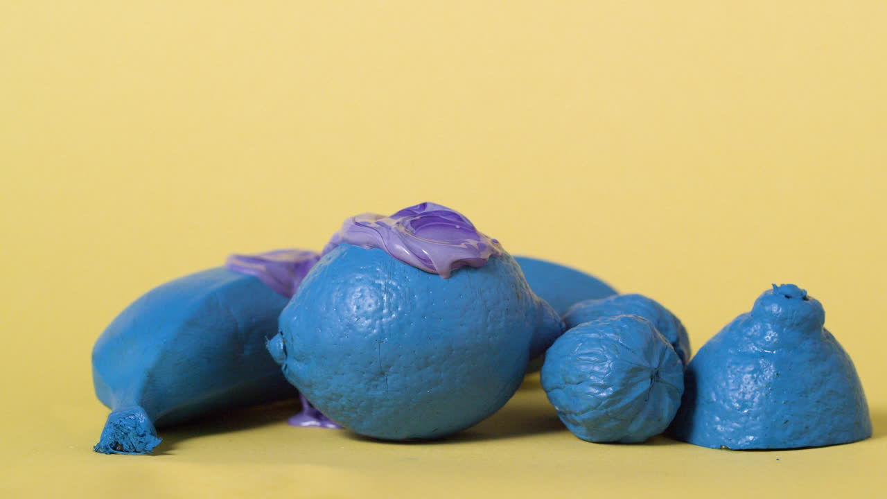 액체가 떨어지는 노란색 파스텔 바탕에 파란색 색의 과일의 다채로운 순서