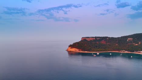 Calm endless seascape of the calm Mediterranean Sea. Some yachts are on the waterscape near the shore. Rocky coast of Kemer, Turkey. Aerial view