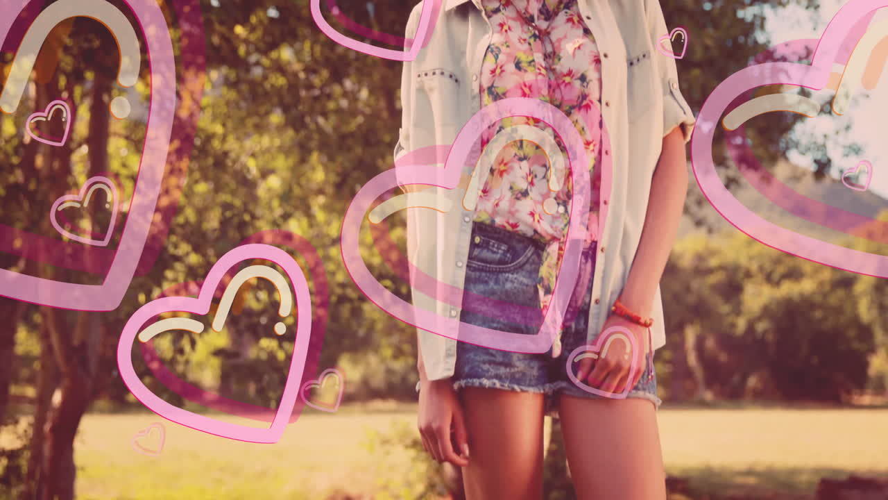Young woman in floral shirt and denim shorts with pink heart animation overlay