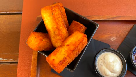 palitos de polenta fritos y palitos de queso, tapas tradicionales en un restaurante, toma de 4k