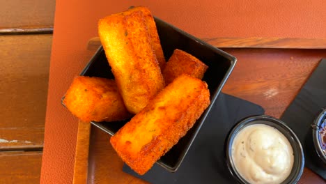 deep fried polenta chips sticks and cheese sticks, traditional tapas in a restaurant, 4k shot