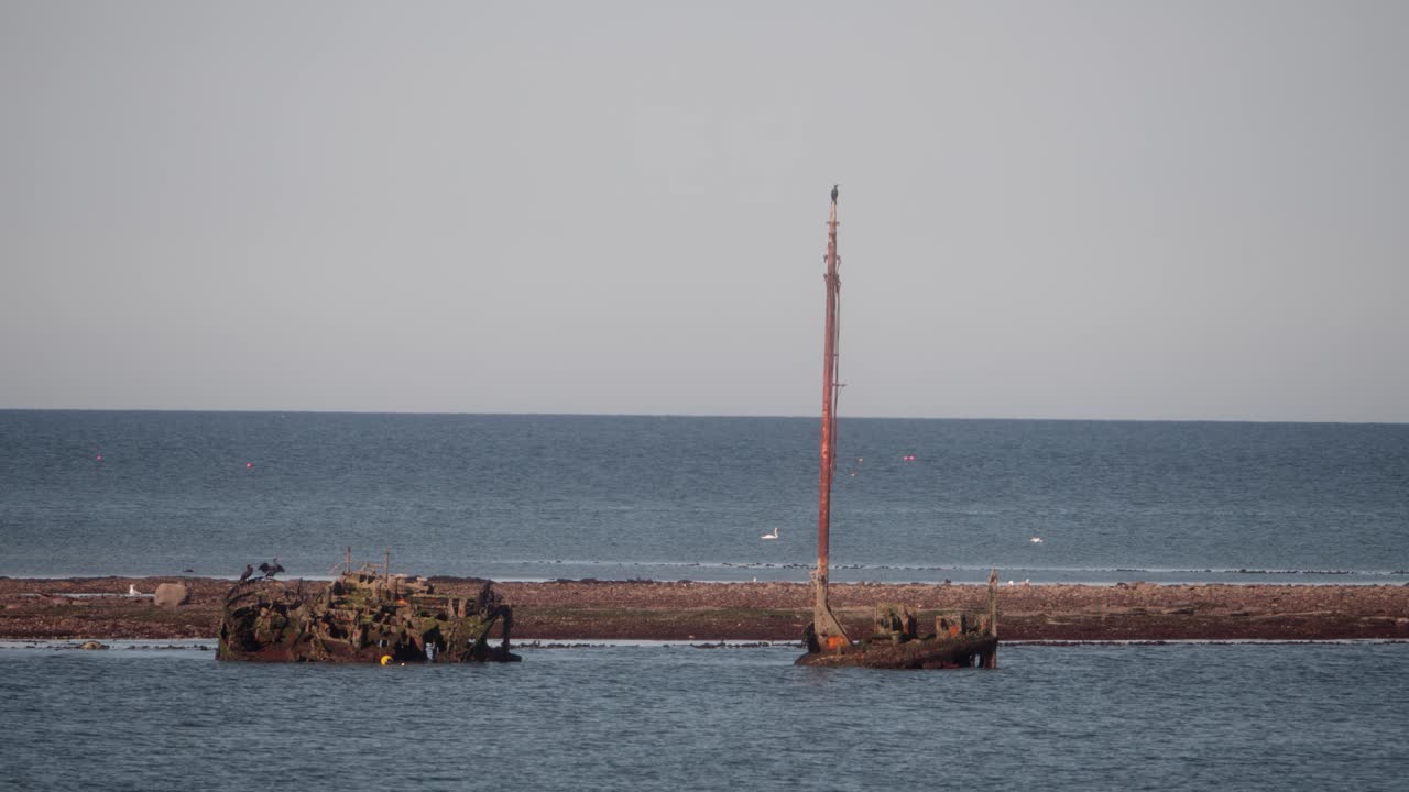 Decaying rusted vessel wreck, corroded mast, maritime boating history
