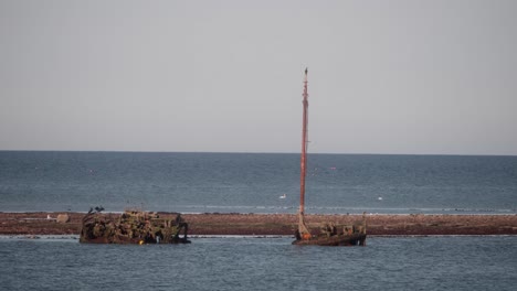 decaying rusted vessel wreck, corroded mast, maritime boating history