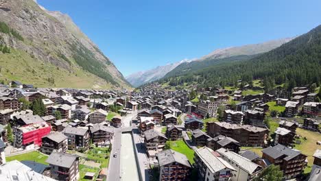 Flying-over-Zermatt-overlooking-the-tranquil-and-peaceful-alpine-village-during-the-beautiful-spring-day-in-Swiss-Alps,-Switzerland,-Europe