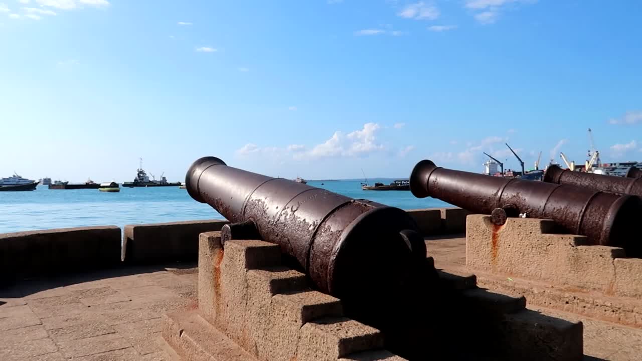 포로다니 항구에서 항해하는 보트와 함께 오래된 녹슨 대포의 패닝 샷