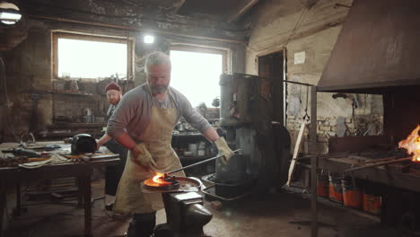 blacksmith shaping heated iron rod in workshop