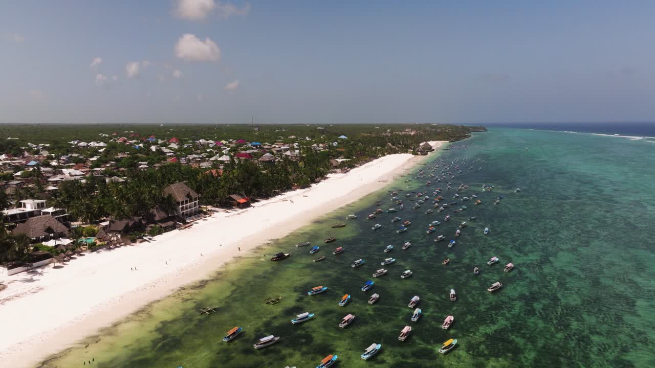 Matemwe beach, High aerial ascend over boats anchored off of Zanzibar beach and reef system with pristine blue water and thin white shoreline