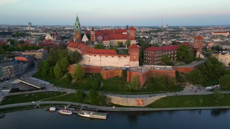 Drohnenaufnahme-Des-Wawelschlosses-In-Krakau-Bei-Sonnenuntergang,-Polen,-Mit-Flug-Von-Links-Nach-Rechts-In-Einer-Geraden-Horizontalen-Linie-Mit-Blick-Auf-Die-Weichsel