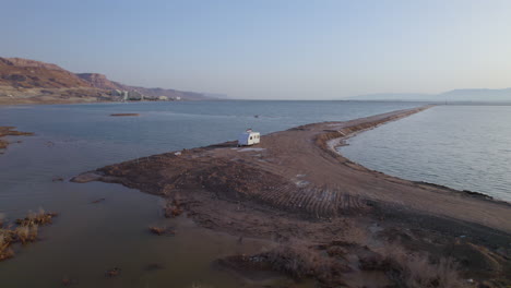 lonely-white-trailer-parked-on-one-of-the-sand-dikes-separating-the-Dead-Sea