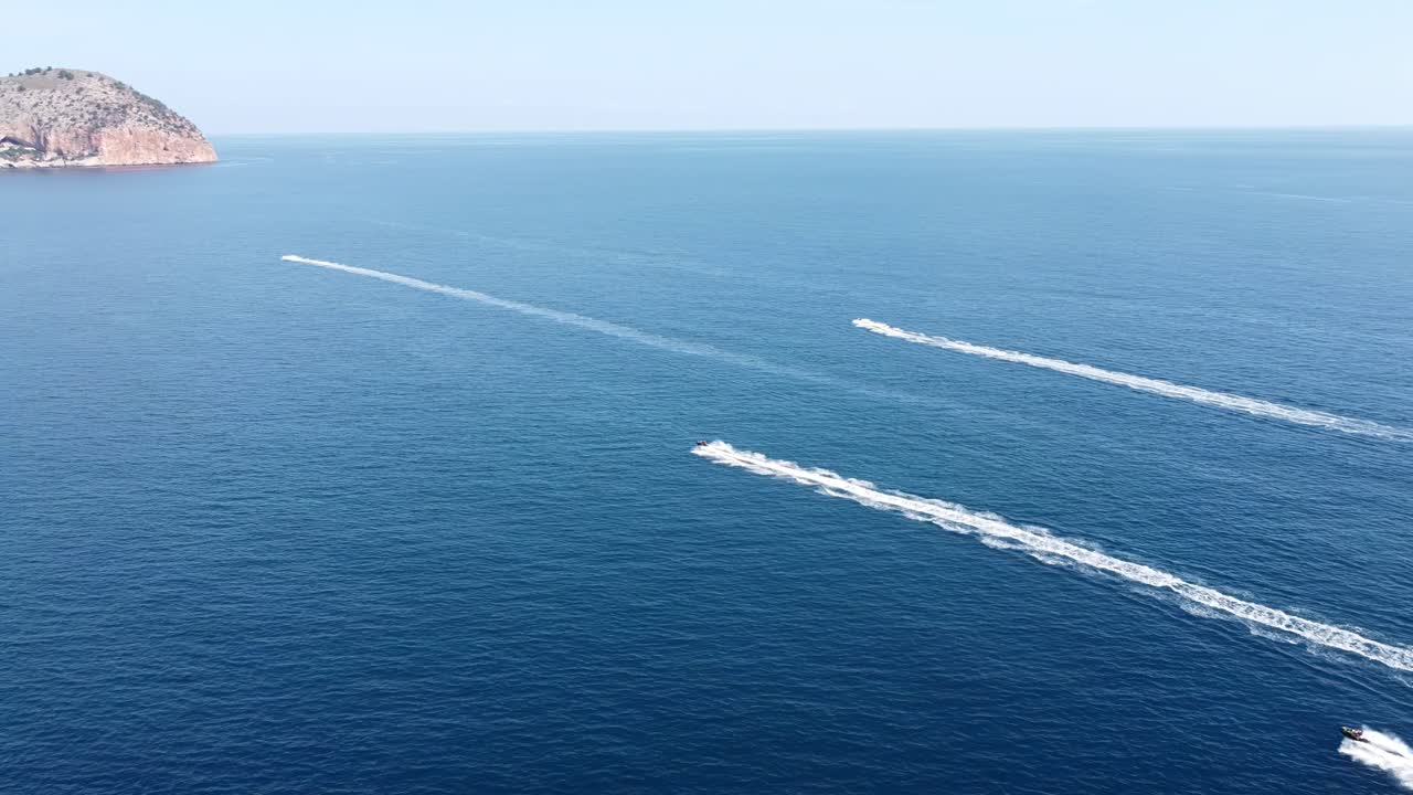 Scenic aerial view of motorboats sailing on sea near rocky coast