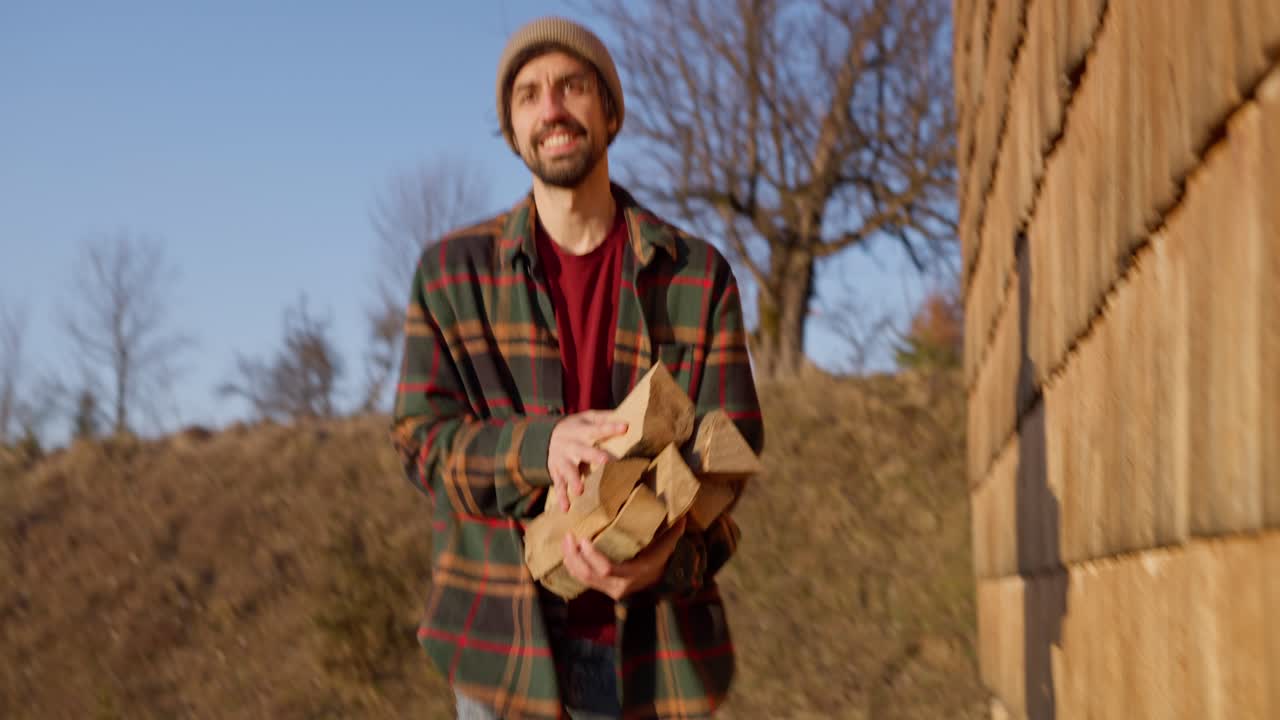 Man carrying firewood outdoors