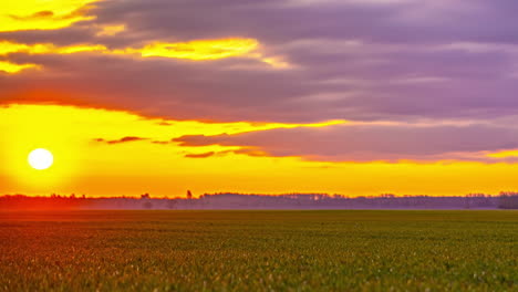 Timelapse-Del-Amanecer-Dorado-Sobre-Un-Vasto-Campo-Con-Un-Cielo-Nublado