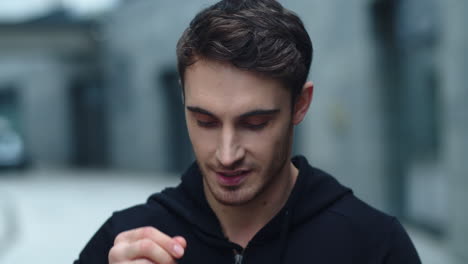 hombre sonriente en primer plano con auriculares inalámbricos. corredor masculino escuchando música