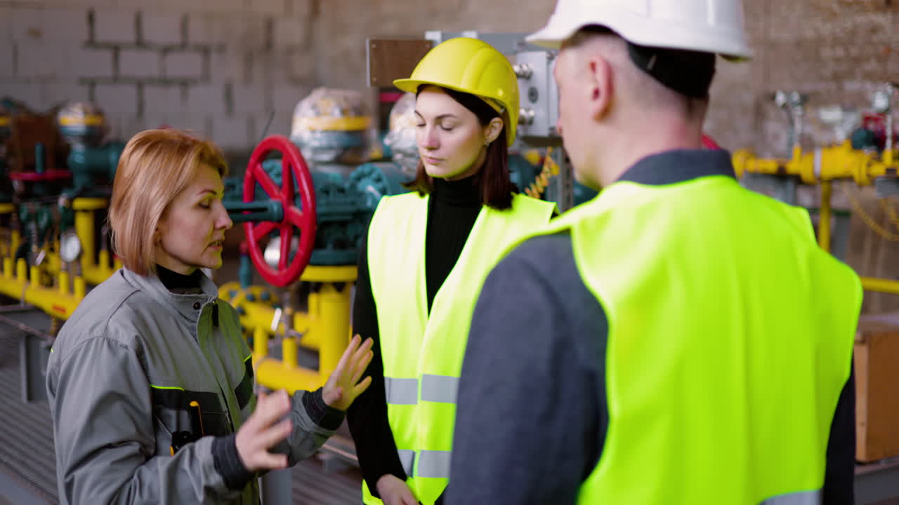 금발 기술자가 엔지니어들에게 문제를 설명하고 있습니다.