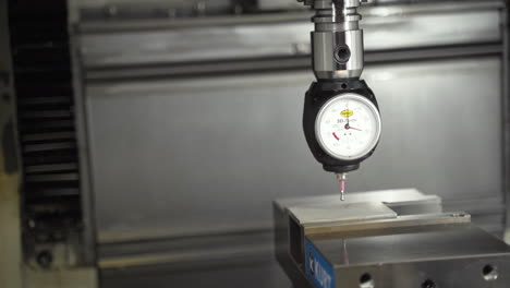 3d taster dial indicator on a cnc machine lowered onto a steel bar