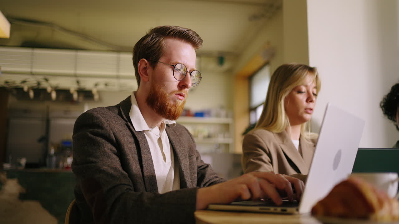 두 사람이 카페에서 함께 일하고 있습니다.