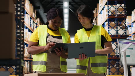 vertical video team of diverse workers handling tracking software for parcel status on tablet