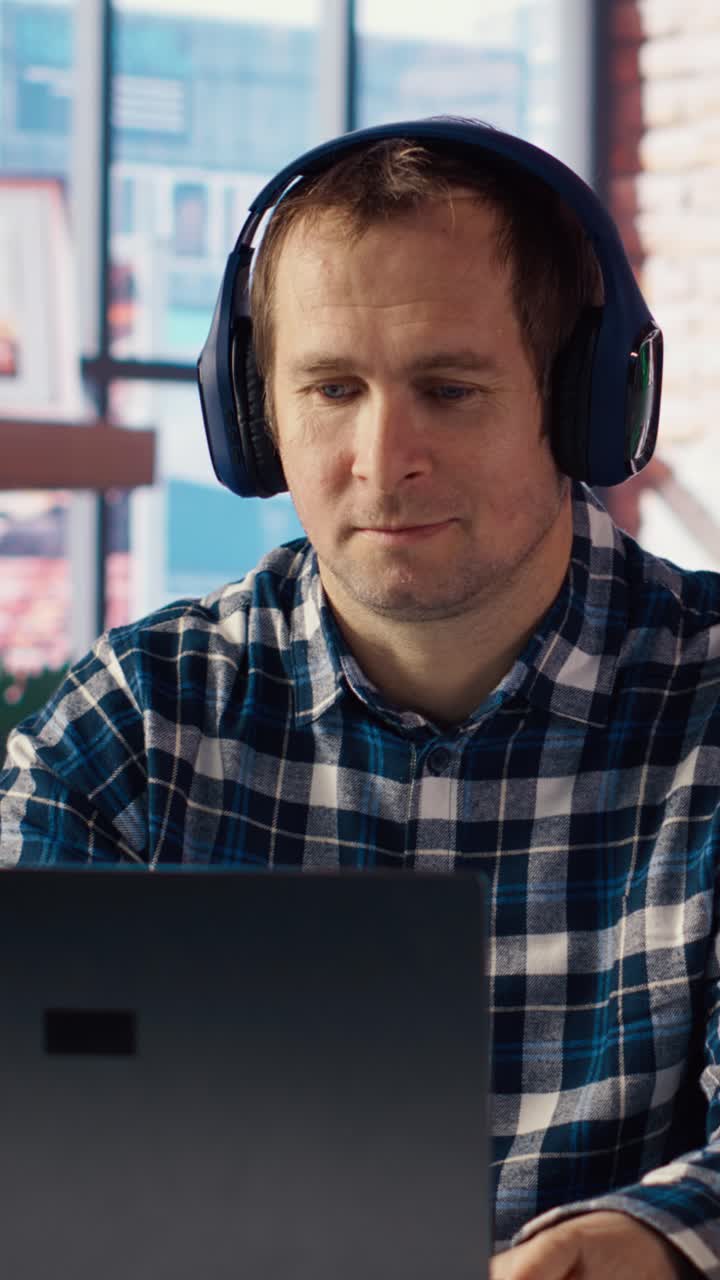 Vertical video Teleworker enjoying music while researching data for company project