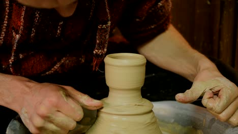 professional male potter working in workshop, studio