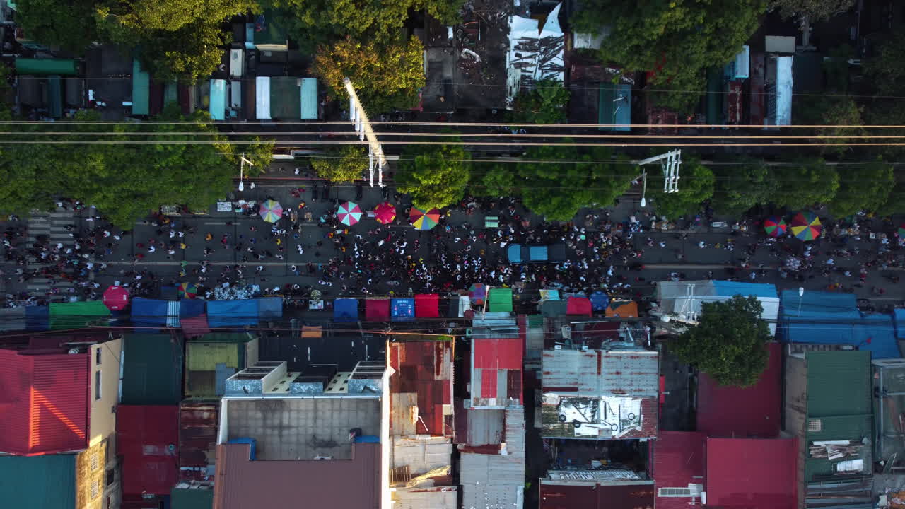 Birdseye drone shot above people celebrating Undas on the streets of sunny Manila