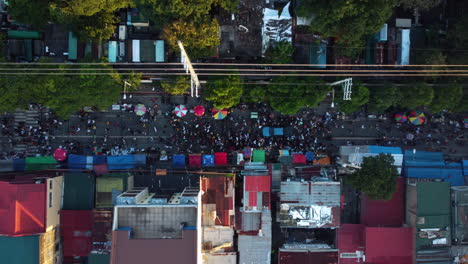 birdseye drone shot above people celebrating undas on the streets of sunny manila