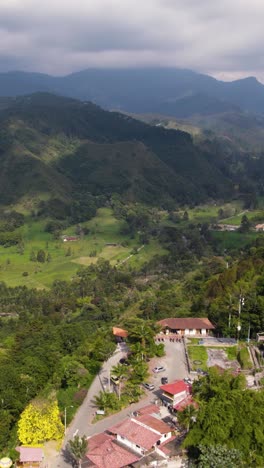 aerial view of salento, colombia, a charming town surrounded by the lush green landscapes of the cocora valley, featuring traditional houses. vertical video