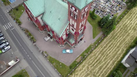 Toma-Aérea-De-Un-Coche-Clásico-Azul-Parado-Frente-A-La-Iglesia.