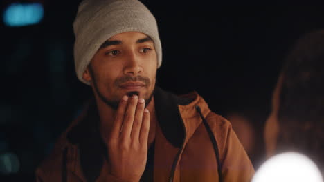 close up young hispanic man staring at woman looking pensive weird rooftop party guy