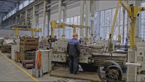 factory workers operating metalworking machinery