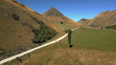 new zealand backcountry on the south island near queenstown - car on a countryside road aerial follow