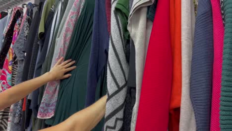 close-up of a woman inspecting second-hand clothes. buying used clothes.