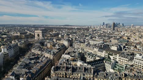 Drone-descending-over-roofs-of-Paris-with-Triumphal-arch-or-Arc-de-Triomphe-in-background,-France