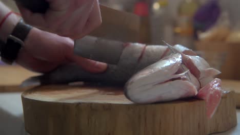 slicing up a sea bass fish to be steam cooked for lunch