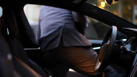 Animation-of-red-shapes-over-man-sitting-in-car