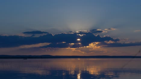 sunset over a lake with a fishing boat