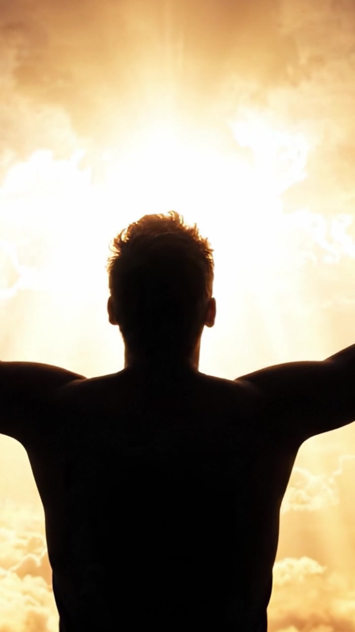 Una Silueta de Pie contra un Dramático Cielo Iluminado por el Sol, Abrazando la Calidez y la Energía del Momento en una Escena de Paz y Reflexión