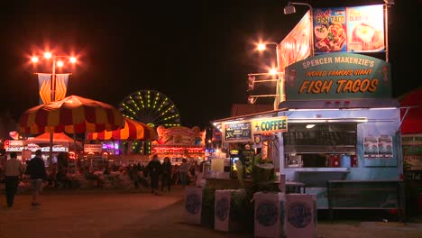 establishing shot of an amusement park carnival or state fair at night