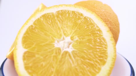 Close-up-fresh-valencia-orange-sliced-with-white-background-shallow-focus-and-slowly-rotating