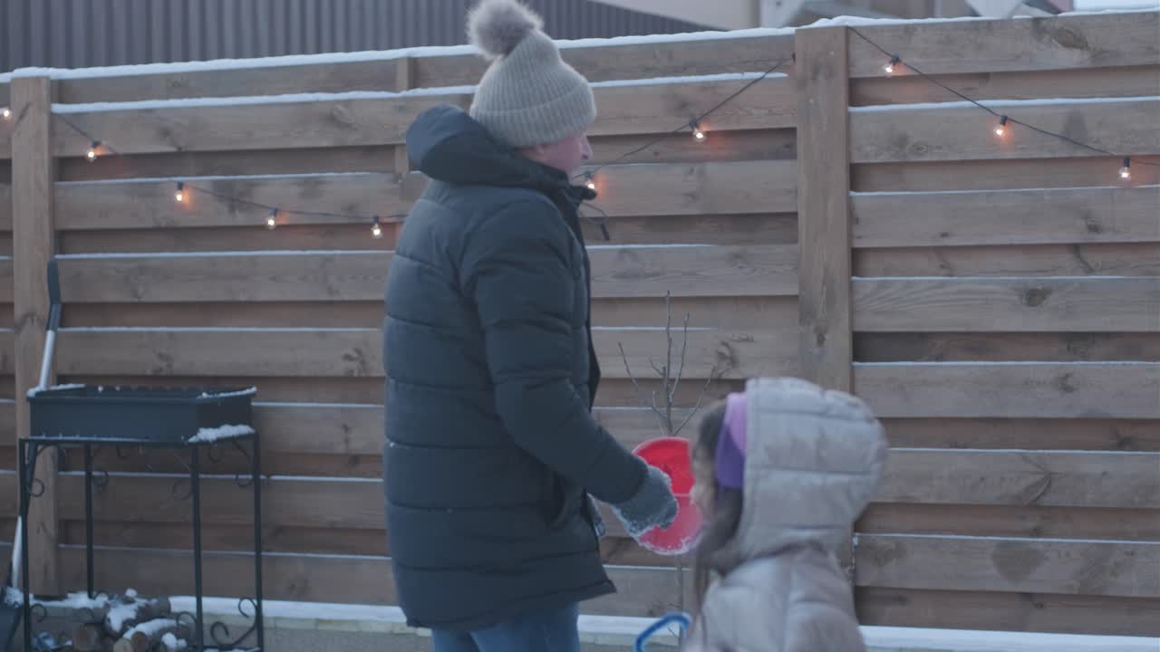 할아버지와 손녀가 눈 속에서 재미를 느끼고 있습니다.