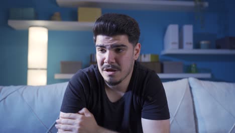 hombre emocional en casa con lágrimas en los ojos.