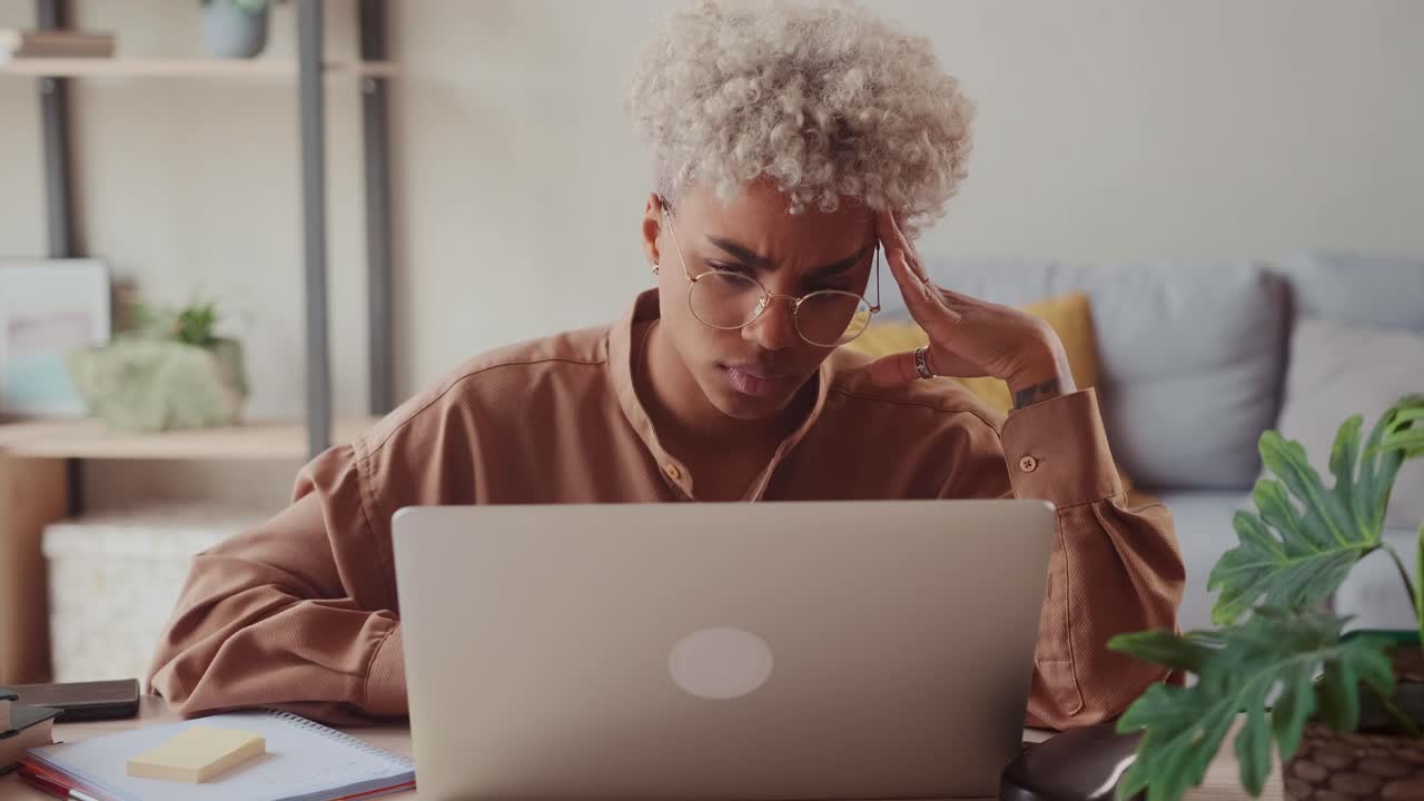 African lady using laptop at home frustrated shocked after reading bad news