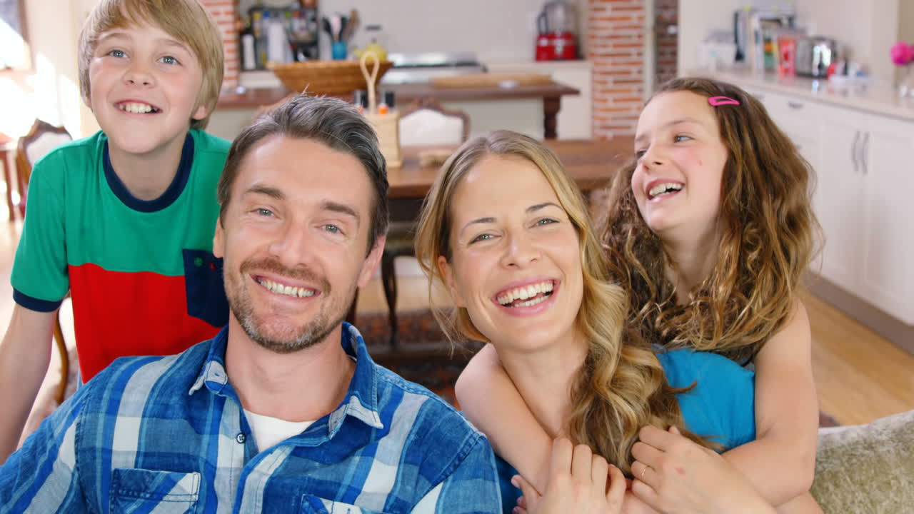 Glad familie smiler på sofaen