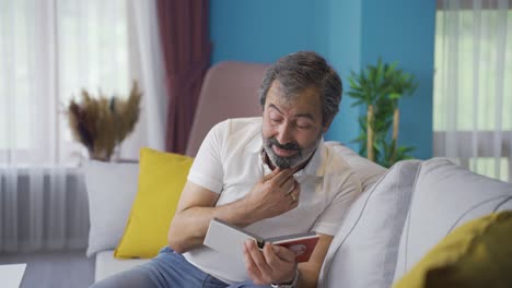 Longing-for-his-child,-the-man-is-sad-and-looking-at-his-child's-album.