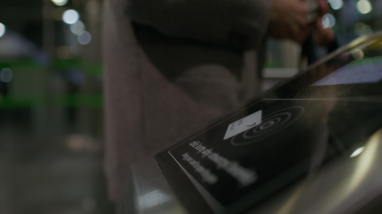 Person using a touch screen kiosk for payment or access control.