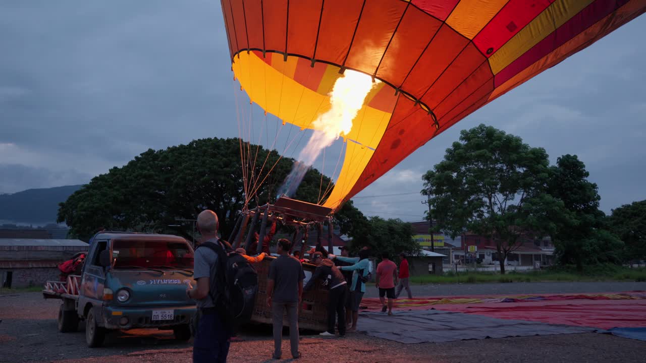 Breath of fire gives balloon birth as excited passengers wait to board
