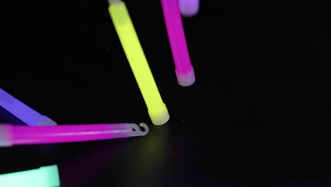 glow sticks falling and landing on dark surface