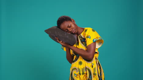 Sleepy-young-adult-taking-a-nap-on-a-grey-pillow-in-studio