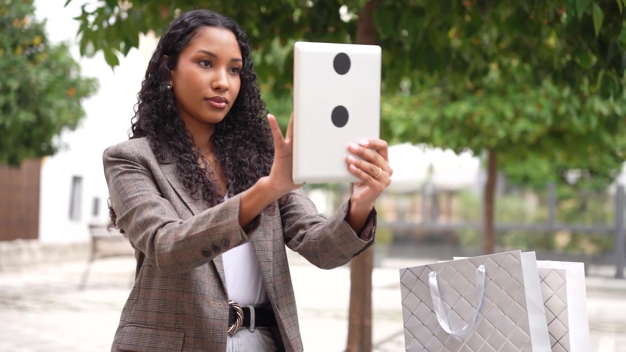 Una donna d'affari sicura di sé che usa il suo tablet all'aperto in una città moderna, mostrando professionalità