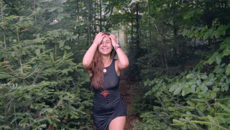 slow motion follow up shot from front of young happy, sexy and beautiful girl, walking with a smiling face in the middle of dense forest