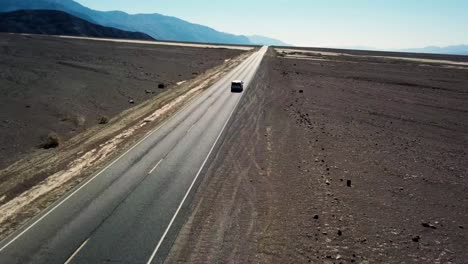 Toma-Aérea-Con-Dron-De-Un-Automóvil-Circulando-Por-El-Valle-De-La-Muerte-En-California,-EE.-UU.